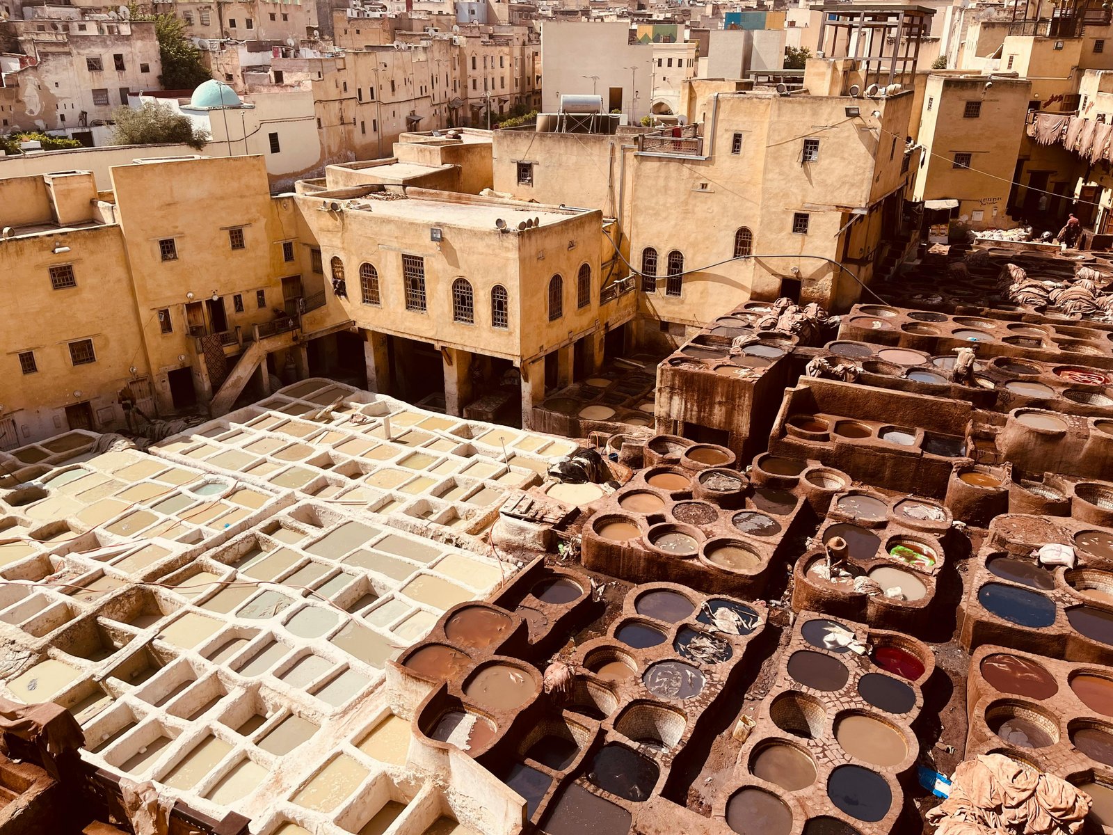 Aerial photo of vibrant traditional tannery in Fez, Morocco, showcasing ancient leather dyeing process.